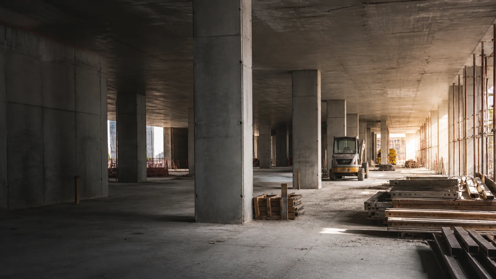Unfinished concrete interior with equipment waiting for work to resume.